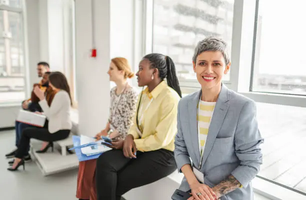 Une femme souriante discutant avec un groupe de jeunes femmes lors d'un atelier de développement personnel à Shreveport.