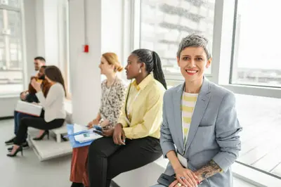 Une femme souriante discutant avec un groupe de jeunes femmes lors d'un atelier de développement personnel à Shreveport.